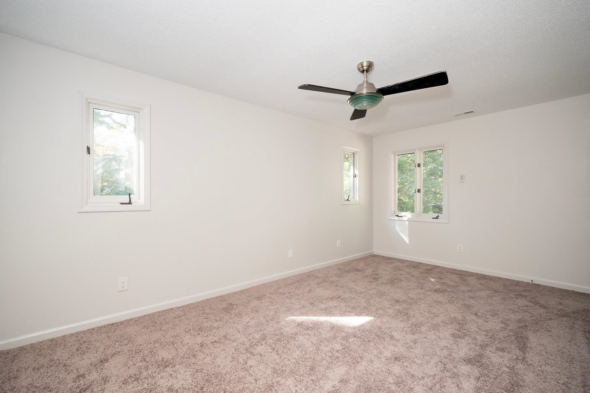 6304 Rushingbrook Drive Raleigh, NC 27612 - Photo 24 of 51 an empty room with windows and fan