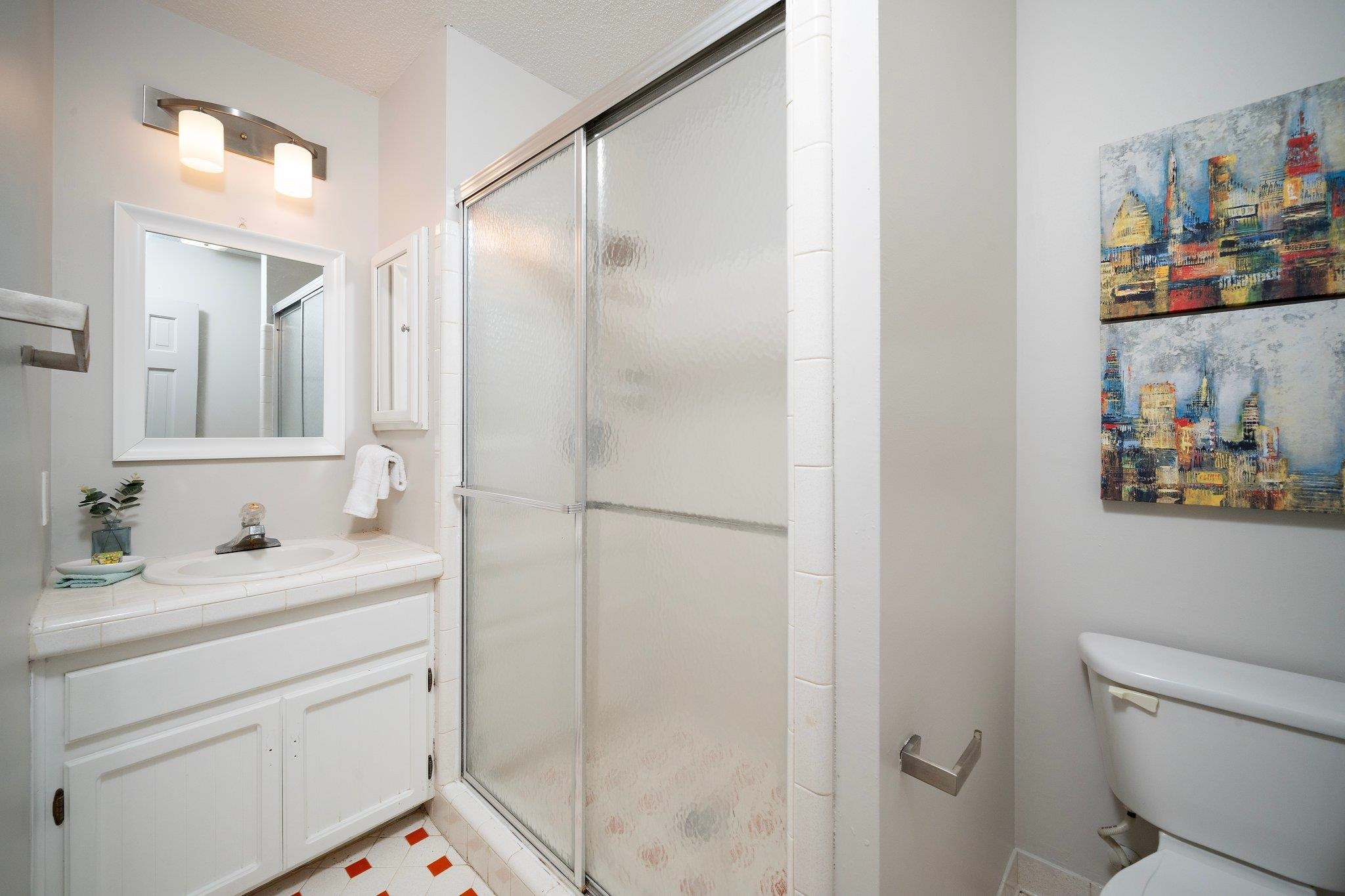 6304 Rushingbrook Drive Raleigh, NC 27612 - Photo 25 of 51 a bathroom with a granite countertop sink a mirror and a shower