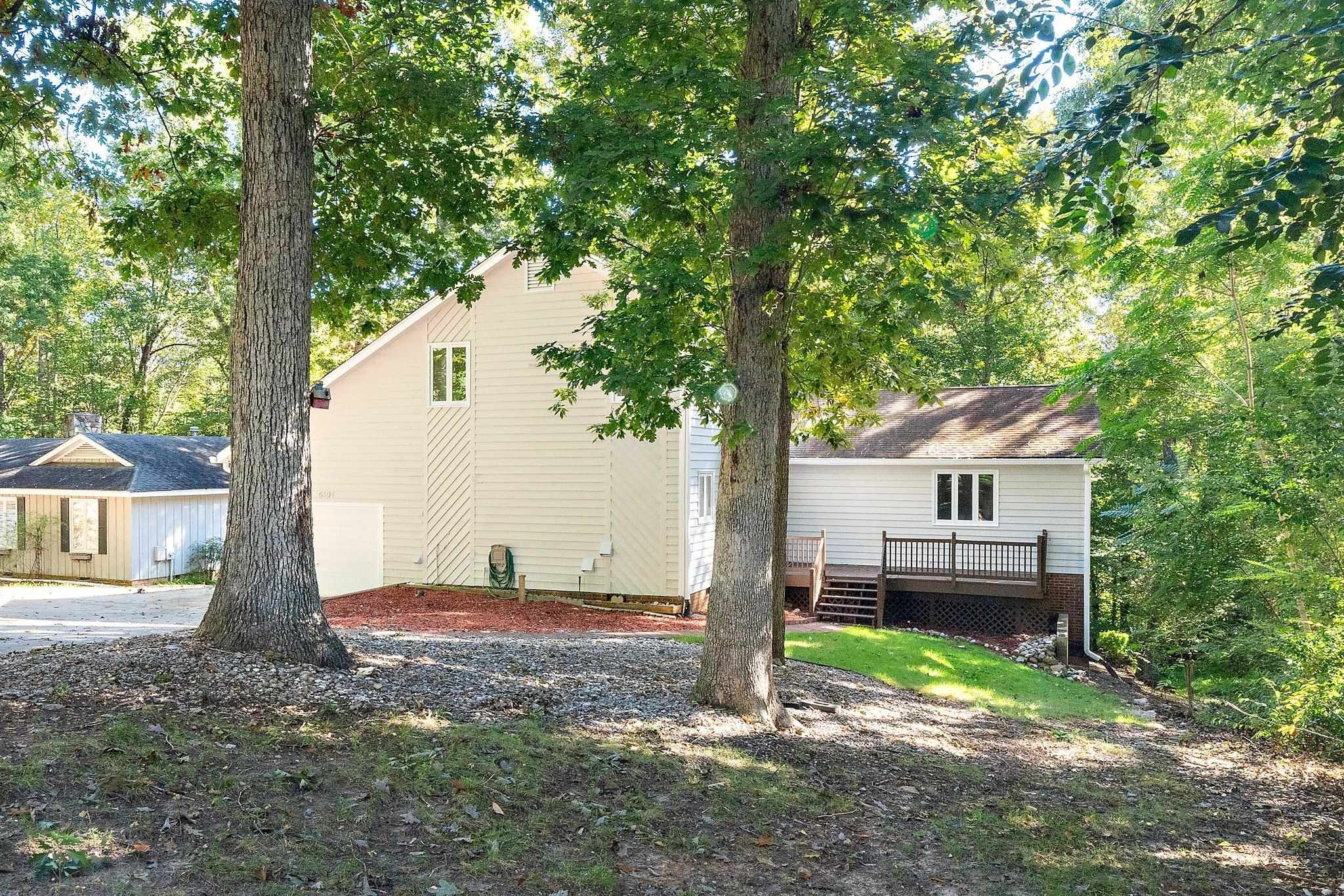 6304 Rushingbrook Drive Raleigh, NC 27612 - Photo 3 of 51 a view of a house with a tree in the forest
