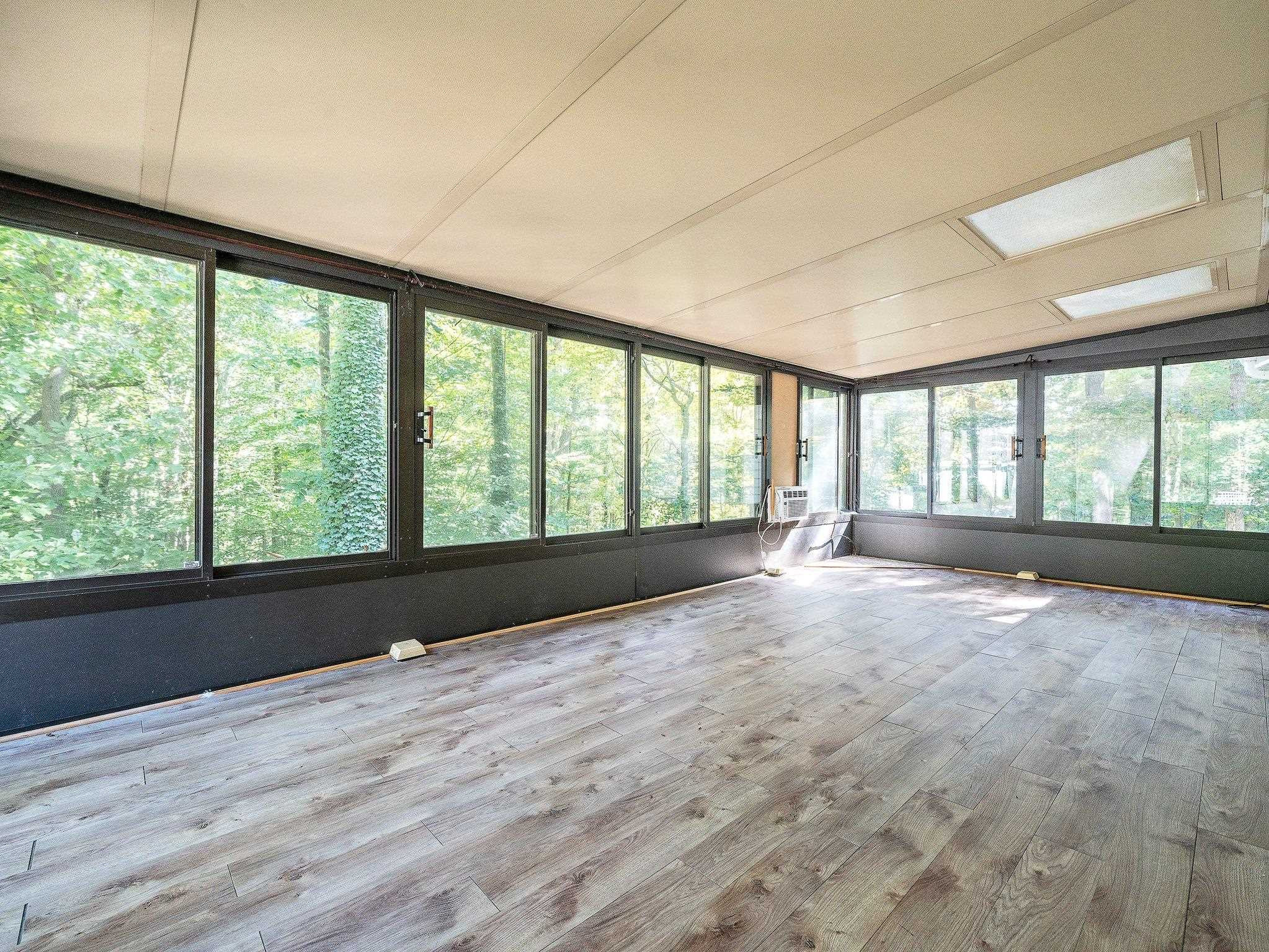 6304 Rushingbrook Drive Raleigh, NC 27612 - Photo 40 of 51 a view of an empty room with a window and wooden floor