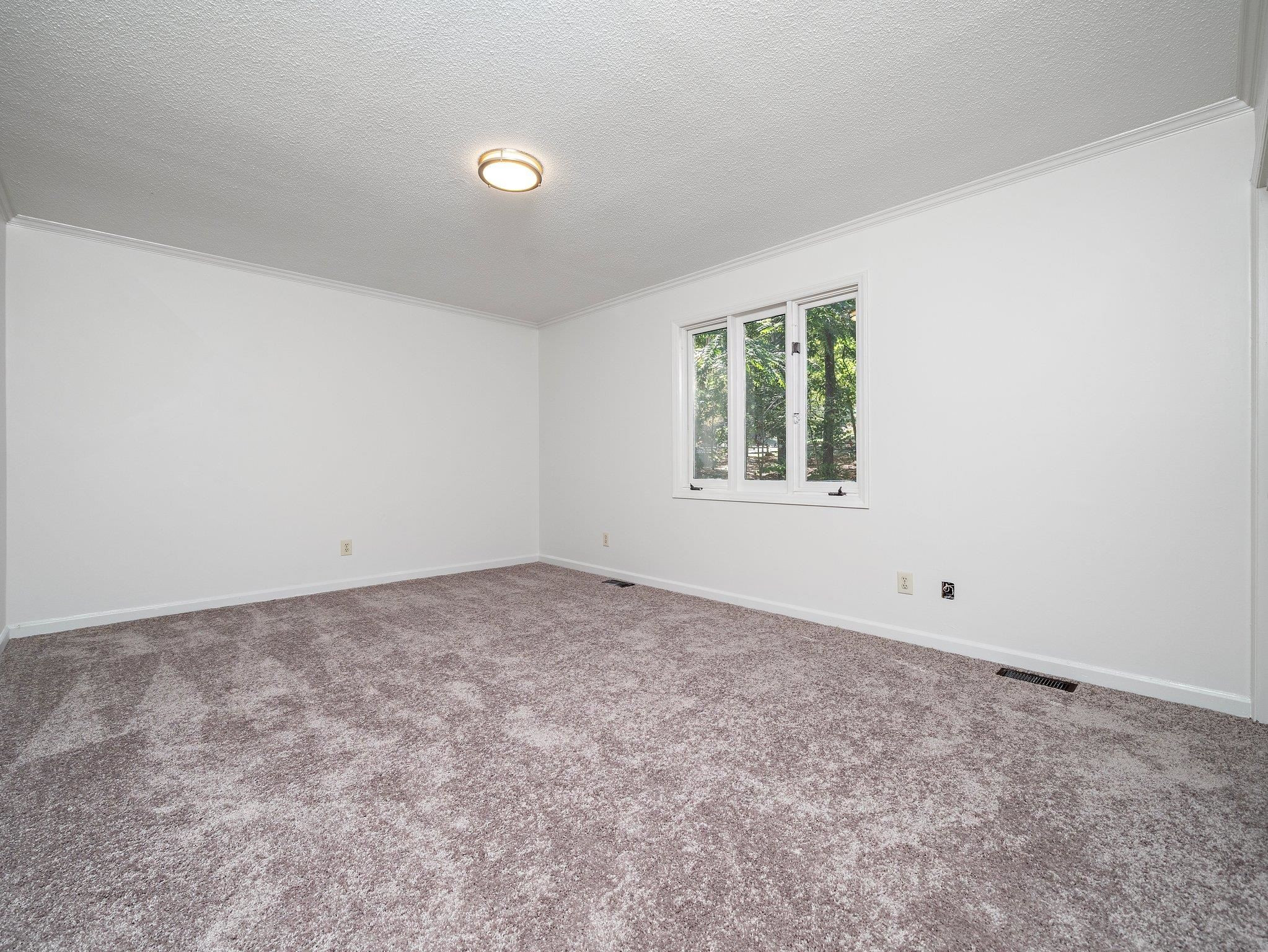 6304 Rushingbrook Drive Raleigh, NC 27612 - Photo 44 of 51 an empty room with a window