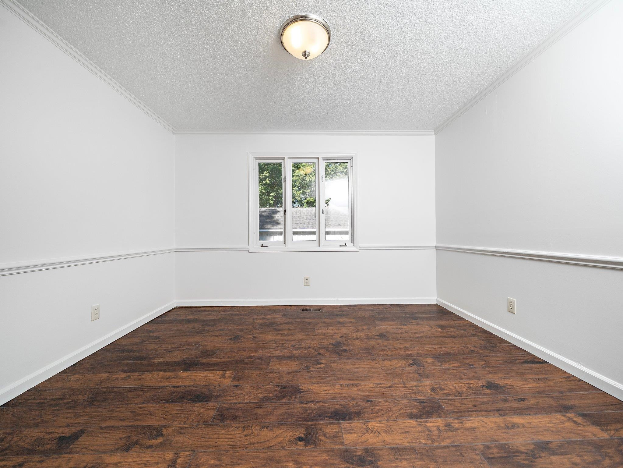 6304 Rushingbrook Drive Raleigh, NC 27612 - Photo 45 of 51 an empty room with wooden floor and windows