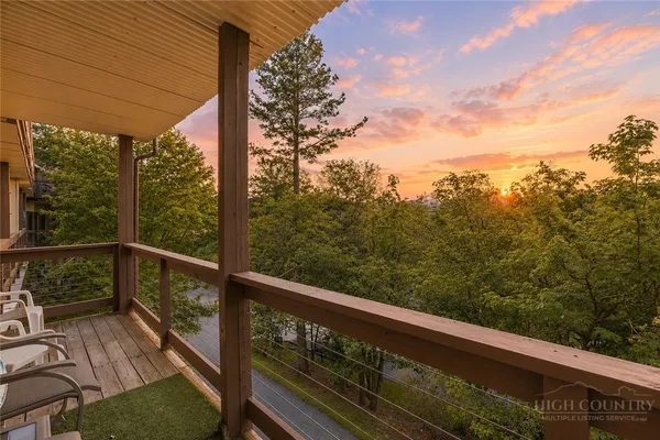 a view of a balcony with wooden floor and fence