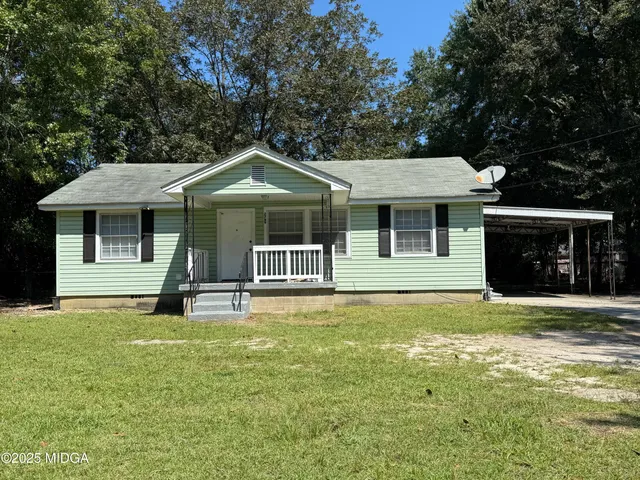 a front view of a house with a garden