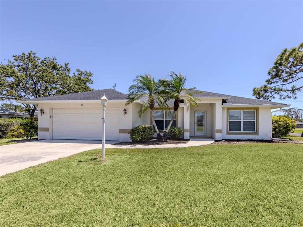 front view of a house with a yard and a garage