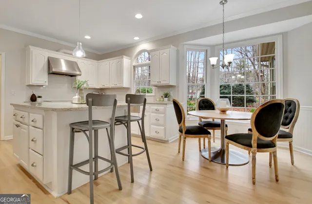 a spacious bedroom with a bed a couch and two windows