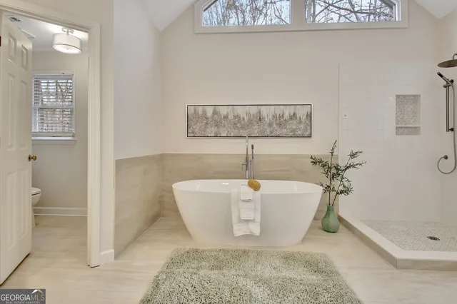 a view of a white house with a big yard and large trees