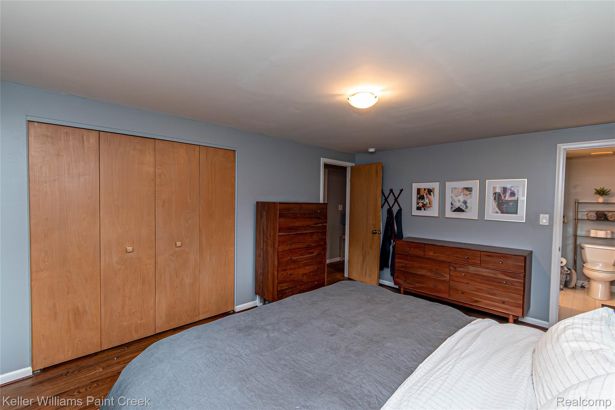 7093 Stonebrook Road West Bloomfield, MI 48322 - Photo 37 of 64 Bedroom featuring light wood-finish bi-fold closet doors, hardwood flooring, and a ceiling-mounted light fixture