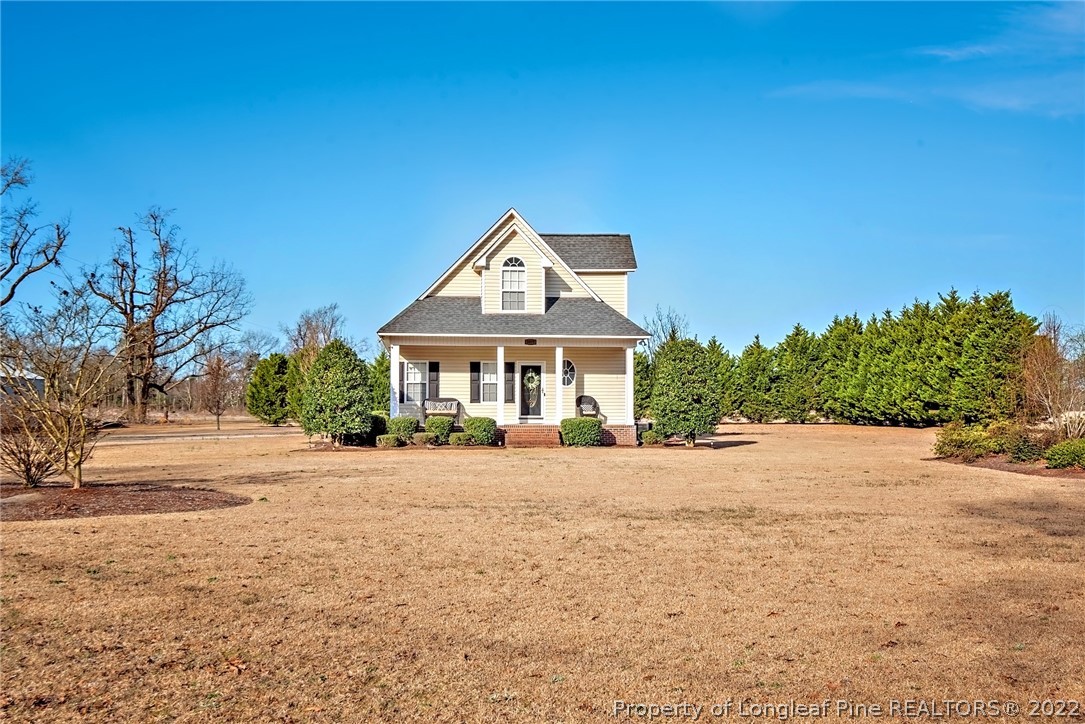 a front view of a house with a yard and trees