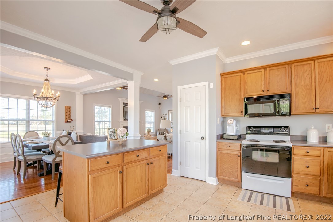 3577 Hayfield Road Wade, NC 28395 - Photo 15 of 47 a kitchen with stainless steel appliances kitchen island granite countertop a stove refrigerator and cabinets