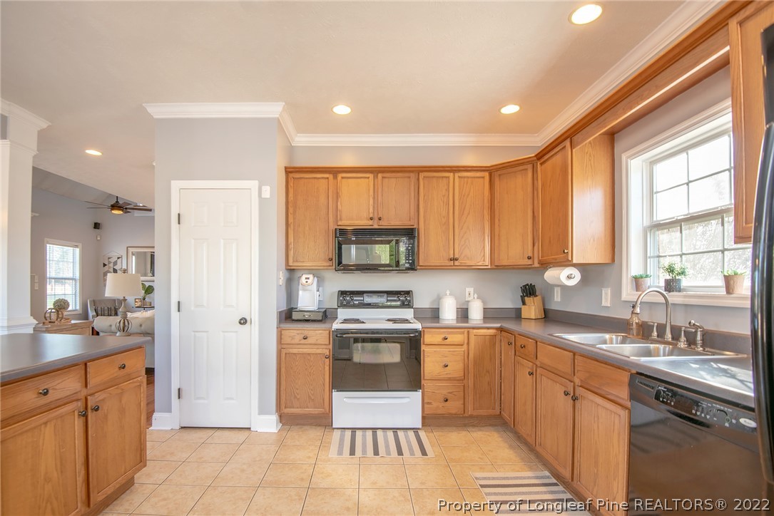 3577 Hayfield Road Wade, NC 28395 - Photo 16 of 47 a kitchen with stainless steel appliances granite countertop a stove top oven a sink a refrigerator and cabinets