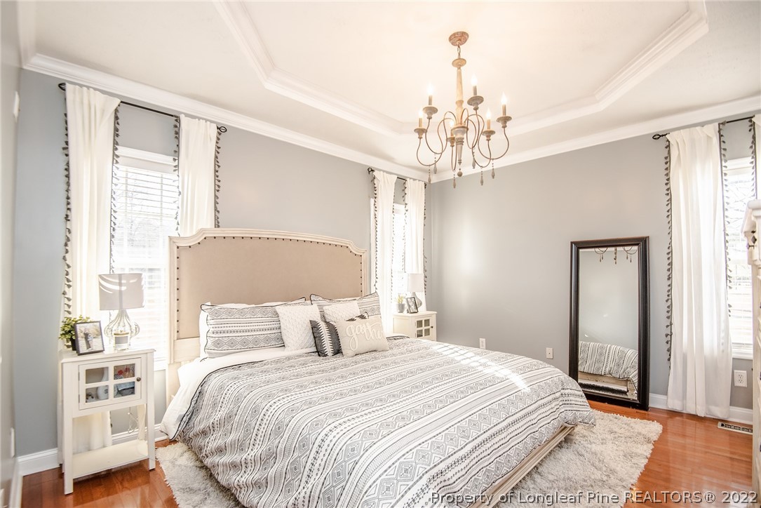 3577 Hayfield Road Wade, NC 28395 - Photo 21 of 47 a bedroom with a large bed and a chandelier