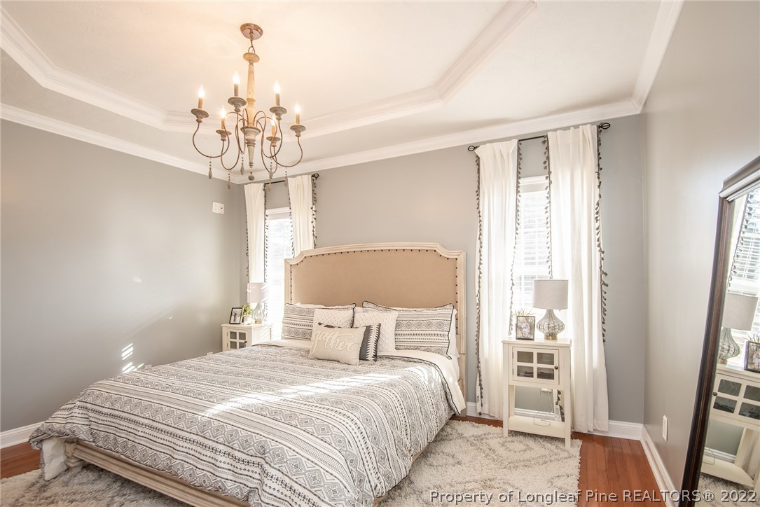 3577 Hayfield Road Wade, NC 28395 - Photo 22 of 47 a bedroom with a bed and a chandelier