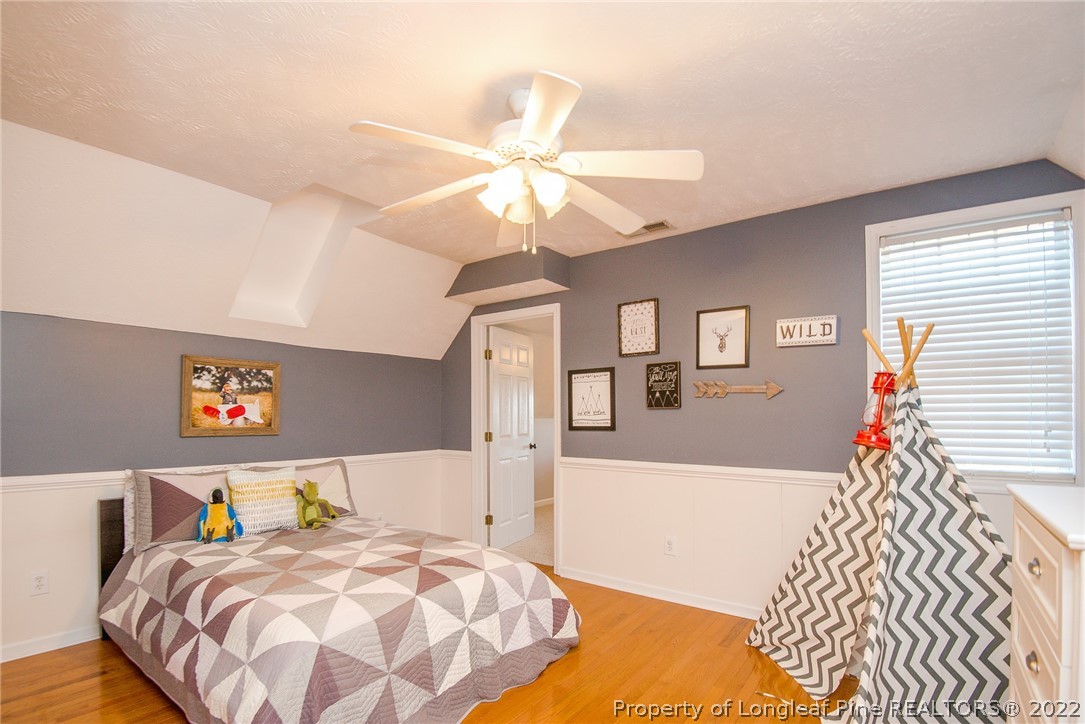 3577 Hayfield Road Wade, NC 28395 - Photo 34 of 47 a bedroom with a bed and a chandelier