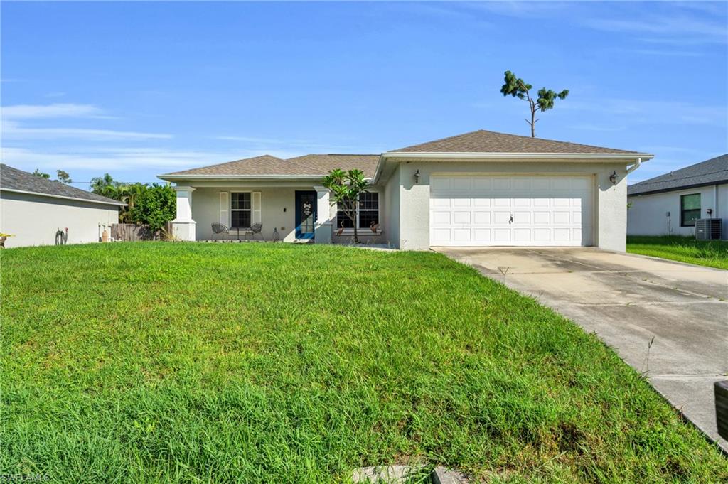8069 Albatross Road Fort Myers, FL 33967 - Photo 1 of 21 Ranch-style house with a garage, central AC unit, and a front lawn