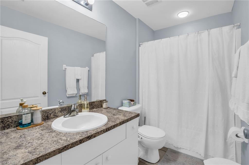 8069 Albatross Road Fort Myers, FL 33967 - Photo 12 of 21 Bathroom with vanity, tile patterned flooring, and toilet