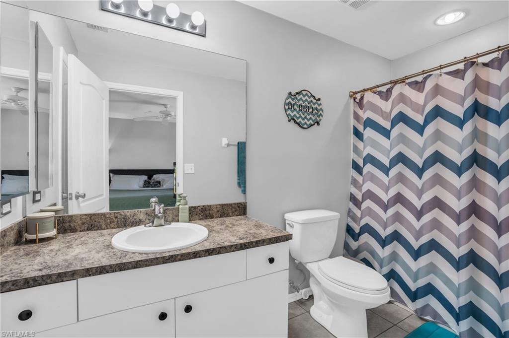 8069 Albatross Road Fort Myers, FL 33967 - Photo 15 of 21 Bathroom featuring vanity, tile patterned flooring, ceiling fan, and toilet