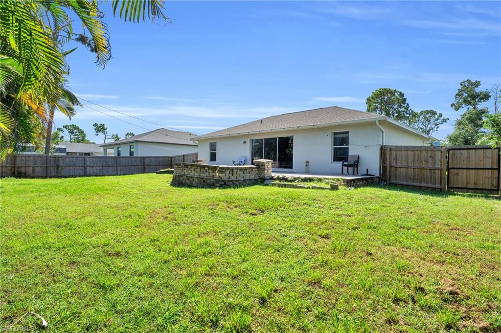 8069 Albatross Road Fort Myers, FL 33967 - Photo 20 of 21 Back of house featuring a patio area and a lawn
