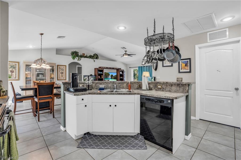 8069 Albatross Road Fort Myers, FL 33967 - Photo 9 of 21 Kitchen featuring light tile patterned floors, white cabinets, dishwasher, ceiling fan, and vaulted ceiling