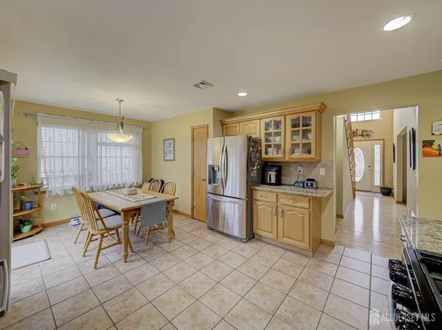 a kitchen with stainless steel appliances kitchen island granite countertop a refrigerator and cabinets