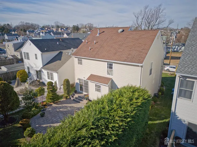 an aerial view of a house with a yard and large tree