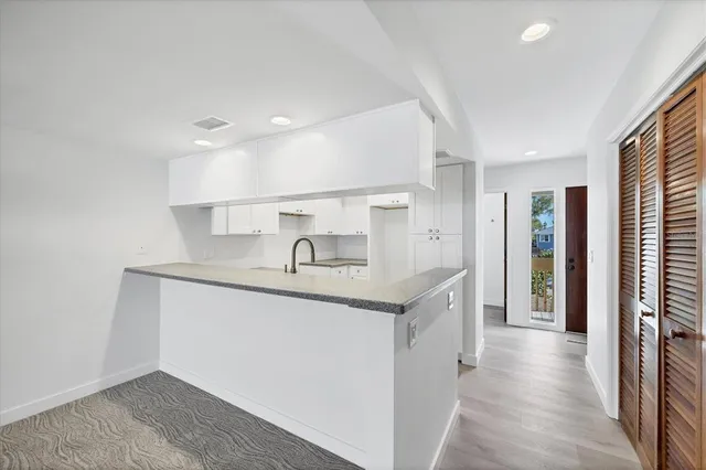 a kitchen with granite countertop a sink a stove and cabinets