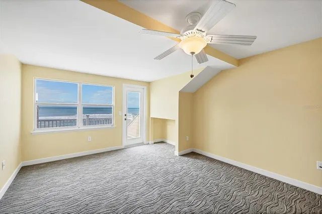 a view of empty room with windows and ceiling fan