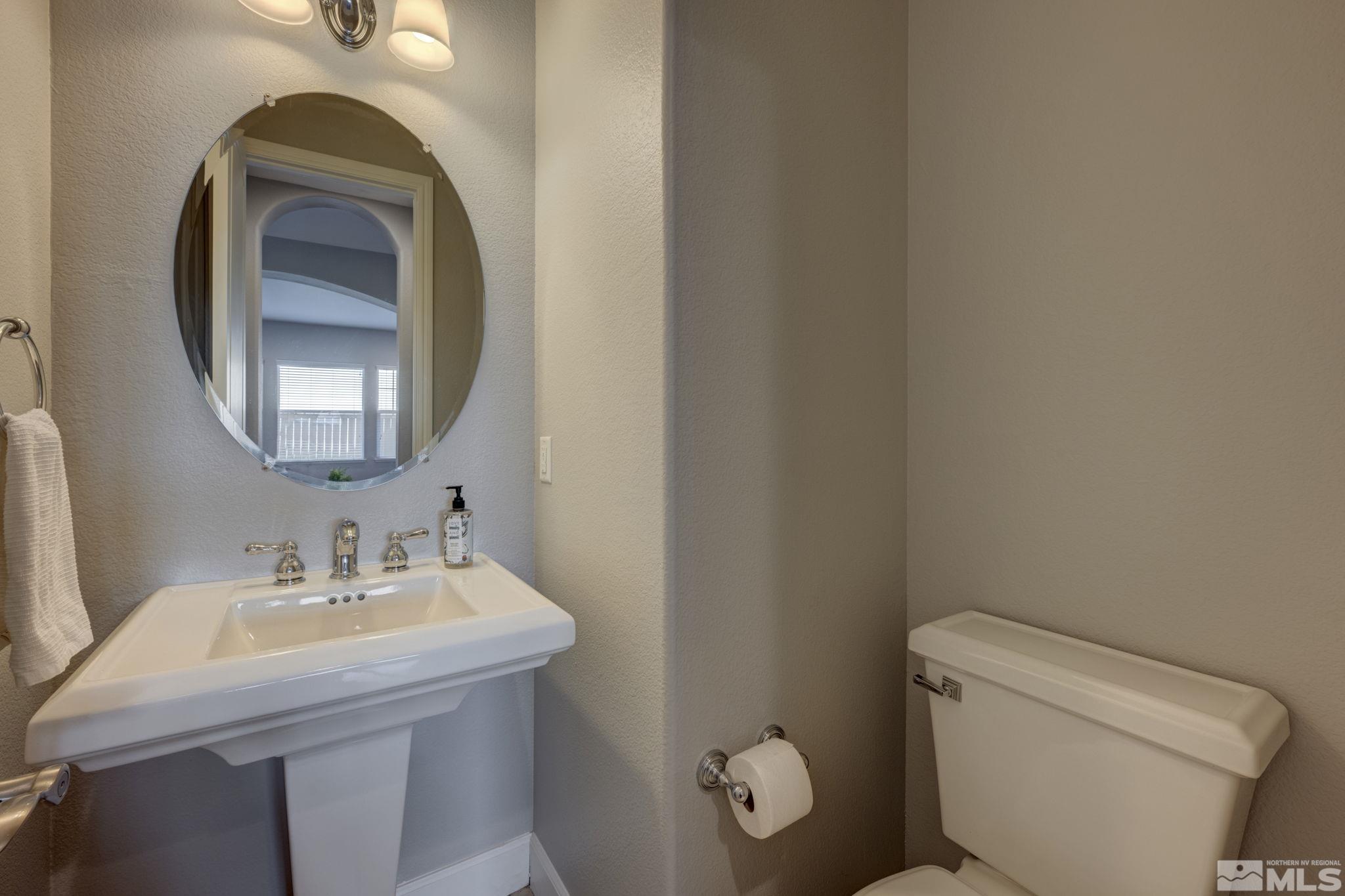 7669 Stone Bluff Way Reno, NV 89523 - Photo 13 of 40 a bathroom with a toilet sink vanity and mirror