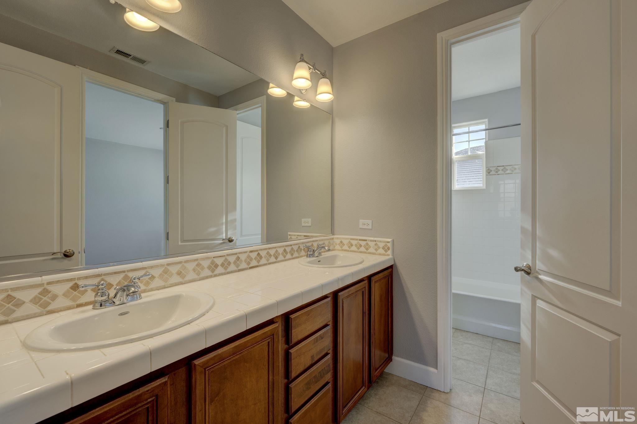 7669 Stone Bluff Way Reno, NV 89523 - Photo 29 of 40 a bathroom with a sink a vanity and a mirror