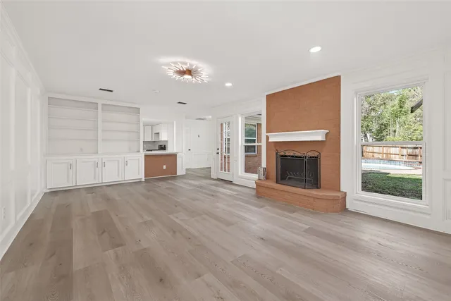a view of empty room with wooden floor and fireplace