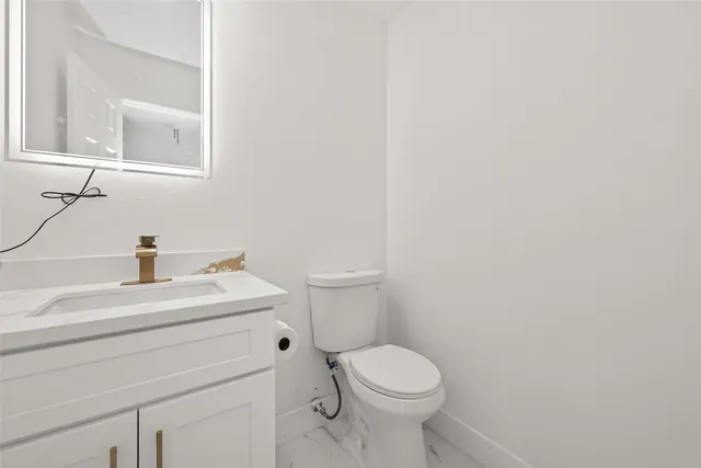 a bathroom with a toilet a sink and mirror