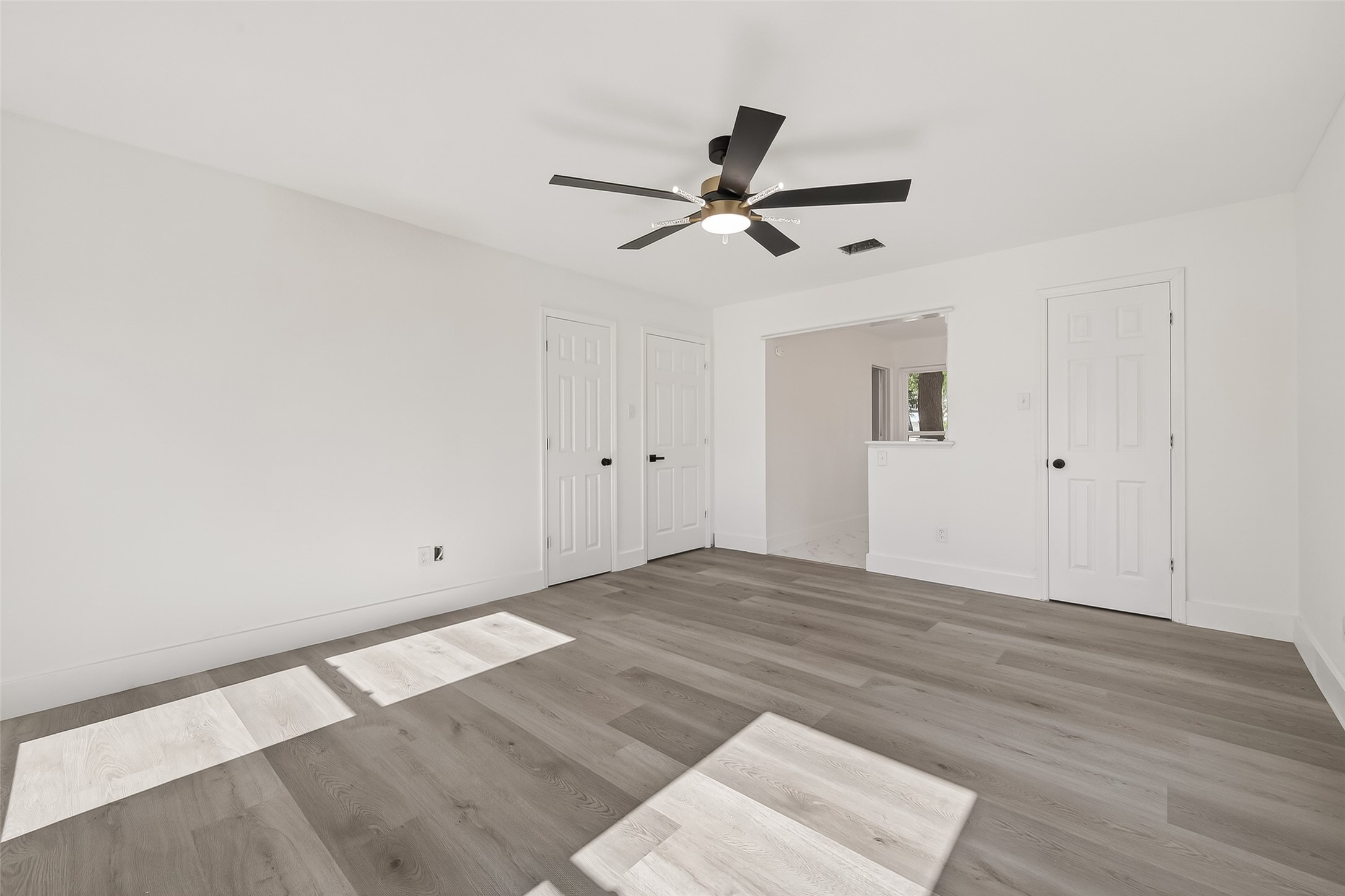 6210 Rippling Hollow Drive Spring, TX 77379 - Photo 25 of 50 an empty room with wooden floor a ceiling fan and windows