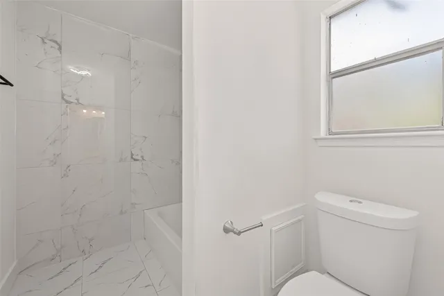 a bathroom with a toilet and a shower