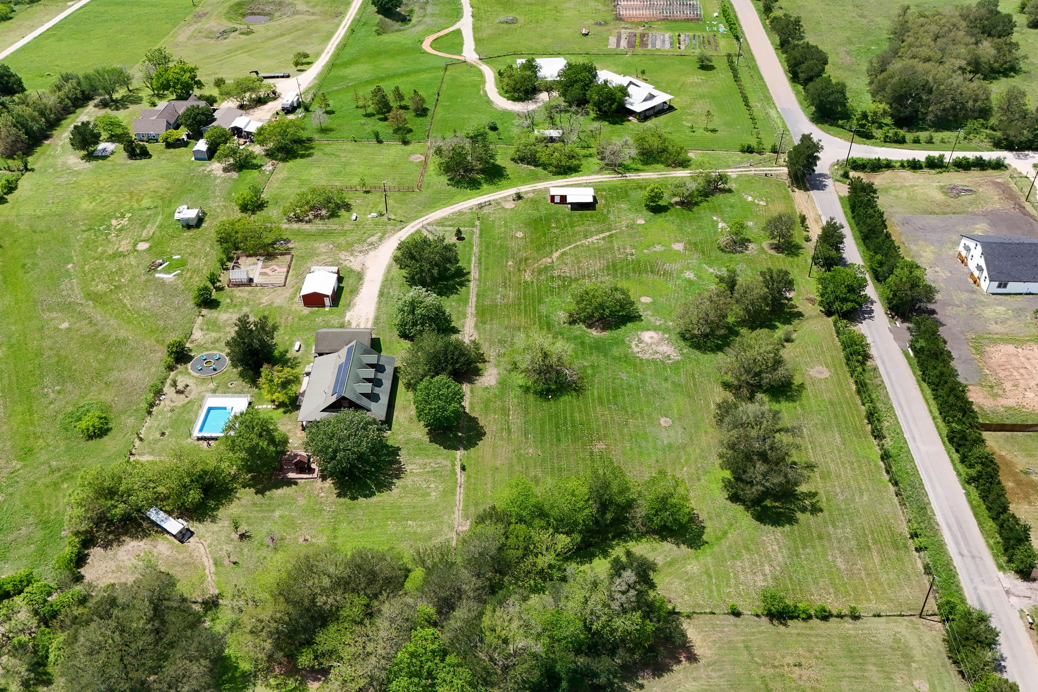 571 Balch Road Elgin, TX 78621 - Photo 32 of 33 Expansive property featuring a main residence with a dark roof and multiple outbuildings