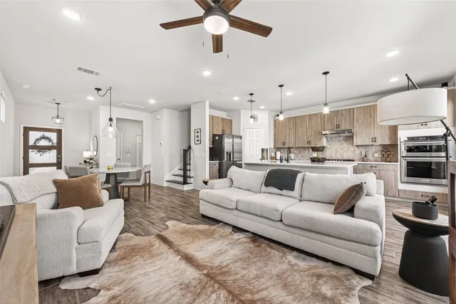 a living room with furniture kitchen view and a chandelier