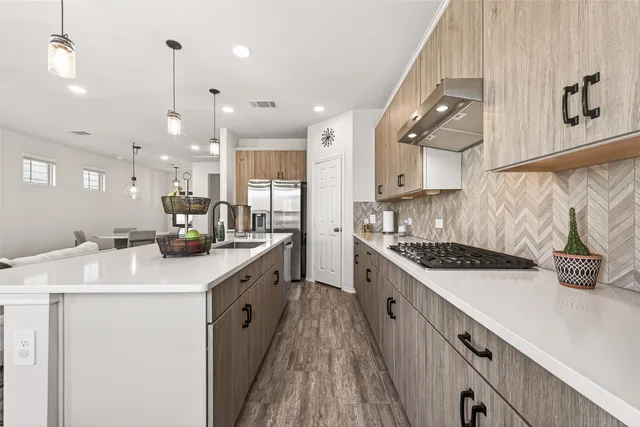 a kitchen with stainless steel appliances sink stove and cabinets