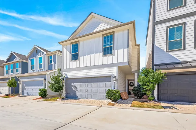 a front view of a house with yard and parking