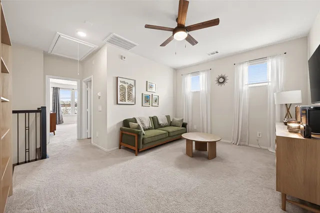 a living room with furniture and a ceiling fan