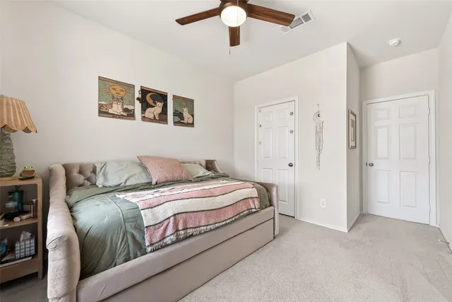 a spacious bedroom with a bed and a chandelier