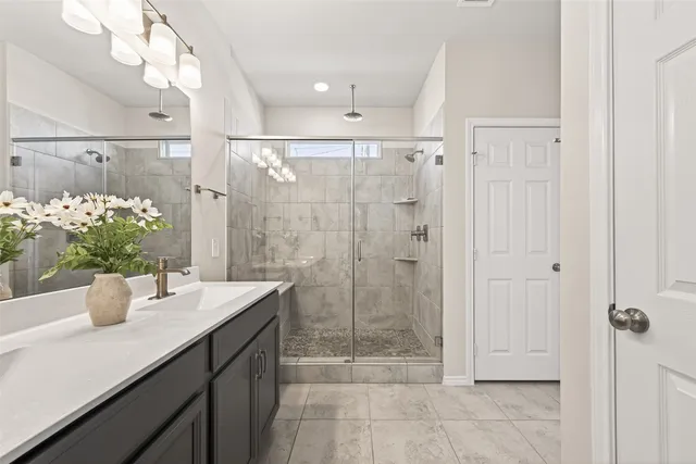 a bathroom with a shower sink and mirror