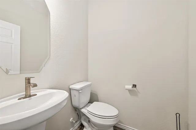 a white toilet sitting next to a white sink