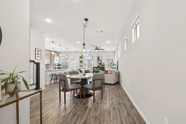a view of a dining room and livingroom with furniture wooden floor a rug and a chandelier
