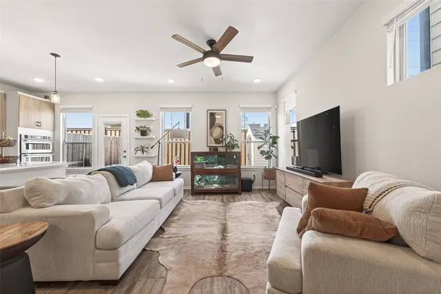 a living room with furniture and a flat screen tv with wooden floor