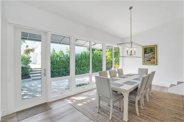 a view of a dining room with furniture large windows and wooden floor