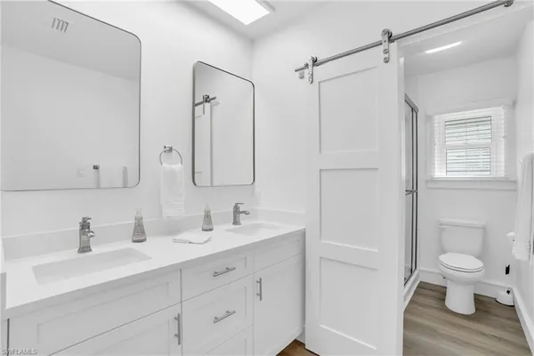 a bathroom with a sink a toilet and a large mirror