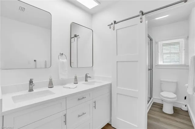 a bathroom with a sink a toilet and a large mirror