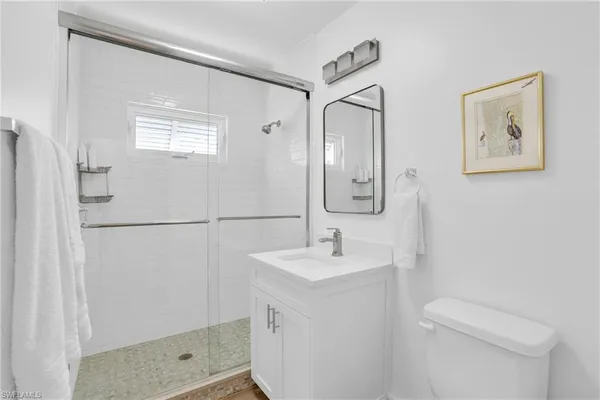 a bathroom with a sink a toilet and shower