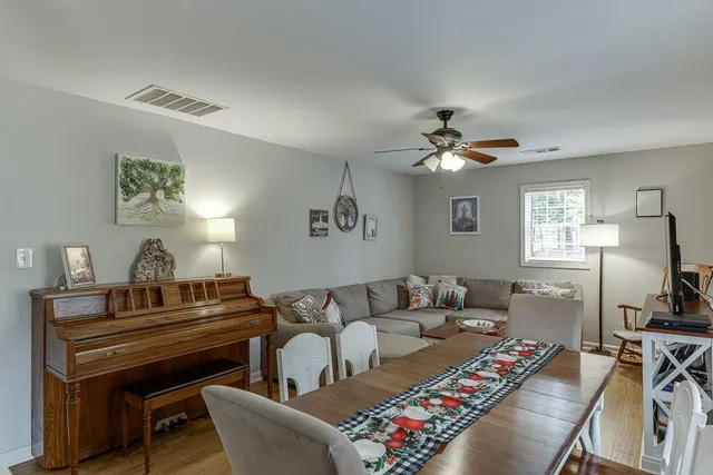 a living room with furniture a chandelier and a piano