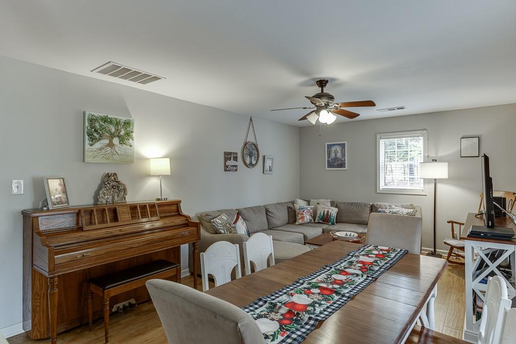 2838 North Bogan Road Northeast Buford, GA 30519 - Photo 7 of 39 a living room with furniture a chandelier and a piano