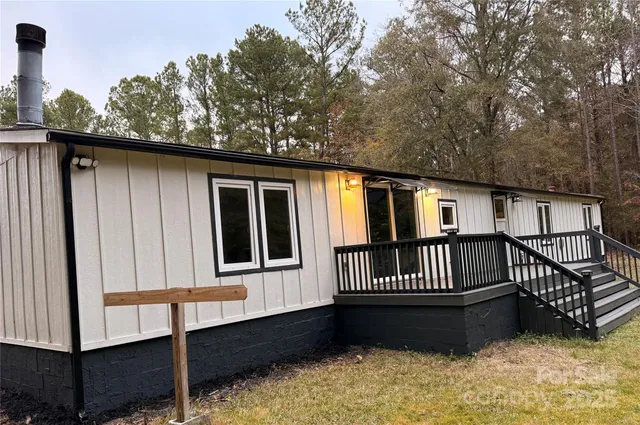 a view of a house with wooden roof and wooden fence